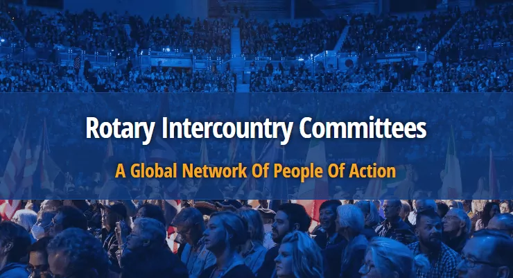 le forum du rotary un public nombreux est assis dans un stade couvert ; au dessus de la foule se trouve une banderole bleue avec le texte "rotary comités interpays a global network of people of action", soulignant l'esprit d'une grande réunion internationale.