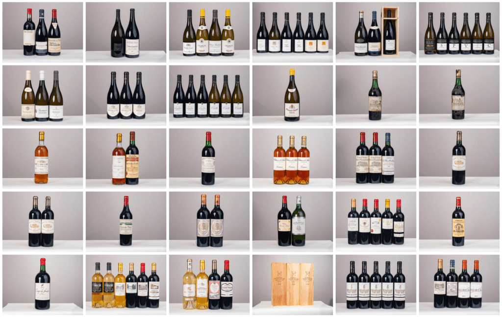 le forum du rotary une grille de 30 étagères présente différents vins, dont des vins rouges, blancs et rosés certains par lots de une à six bouteilles ainsi que quelques caisses de vin en bois, dans l'atmosphère d'une vente ou d'un encan.