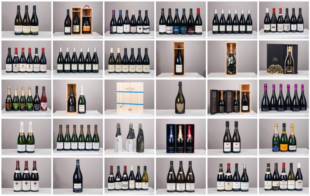 le forum du rotary une grille de 35 images montre diverses bouteilles de vin et de champagne, certaines dans des boîtes en bois ou en carton, disposées pour la vente aux enchères sur des étagères sur un fond neutre. chaque image présente des marques et des étiquettes différentes.